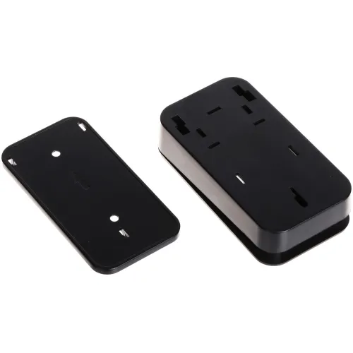 Czarny, prostokątny uchwyt montażowy z tworzywa sztucznego, składający się z dwóch części: podstawy i pokrywy. Obie części mają otwory montażowe i są przeznaczone do mocowania na płaskiej powierzchni.