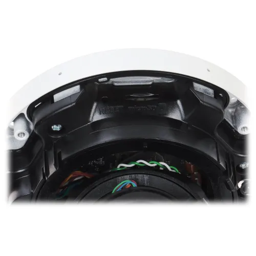 Zbliżenie na wnętrze kamery monitoringu, ukazujące szczegóły montażu i okablowania. Widoczne są elementy plastikowe i metalowe, a także kolorowe przewody.