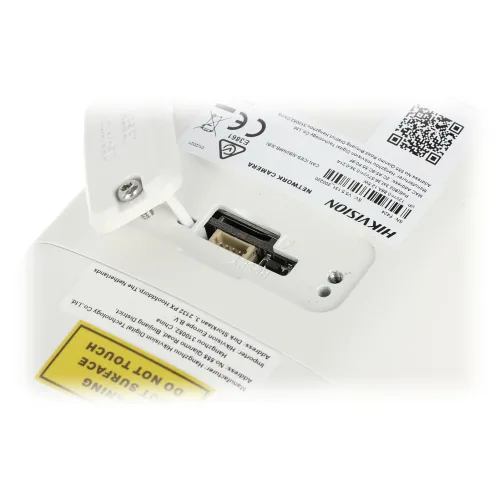 Zdjęcie przedstawia zbliżenie na gniazdo karty pamięci w urządzeniu marki Hikvision, z widocznymi oznaczeniami CE i QR kodem. Obok gniazda znajduje się żółta naklejka z ostrzeżeniem "DO NOT TOUCH".