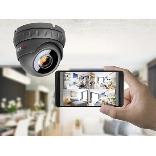 Kamera IP Keeyo LV-I jest zamontowana na suficie, ma kompaktowy, czarny design i obiektyw skierowany w dół. Obok widoczny jest smartfon z aplikacją pokazującą podgląd z kamery w czasie rzeczywistym.