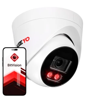 Biała kopułowa kamera IP marki Keeyo z widocznym obiektywem i dwoma czerwonymi diodami LED. Obok kamery znajduje się smartfon z aplikacją BitVision na ekranie.