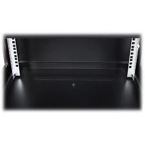 Czarny przepust kablowy w podłodze z metalowymi elementami po bokach. Przestrzeń wewnętrzna jest pusta, z centralnie umieszczonym otworem na kable.