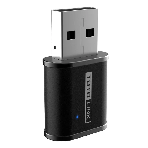 Na zdjęciu znajduje się czarny adapter USB marki TotoLink z widocznym logo na obudowie. Urządzenie ma prostokątny kształt z zaokrąglonymi krawędziami i małą niebieską diodą.