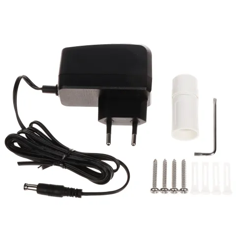 Na zdjęciu znajduje się czarny zasilacz z przewodem, wtyczką i adapterem, obok którego leżą cztery śruby, cztery kołki rozporowe, klucz imbusowy oraz biały element montażowy. Tło jest białe, co podkreśla szczegóły zestawu.