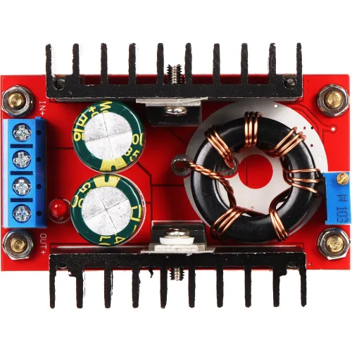 Zdjęcie przedstawia widok z góry na elektroniczny moduł z cewką indukcyjną, kondensatorami i złączami śrubowymi na czerwonej płytce drukowanej. Elementy są otoczone czarnym radiatorem, a całość jest przeznaczona do montażu w urządzeniach elektronicznych.