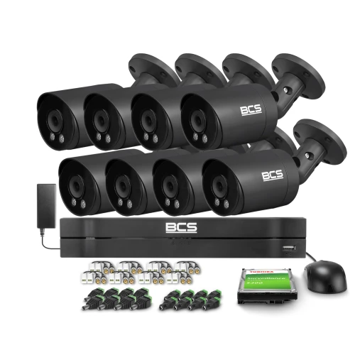 Zestaw do monitoringu składający się z ośmiu czarnych kamer BCS, rejestratora, zasilacza oraz akcesoriów montażowych. W tle widoczny jest dysk twardy Toshiba o pojemności 1TB.