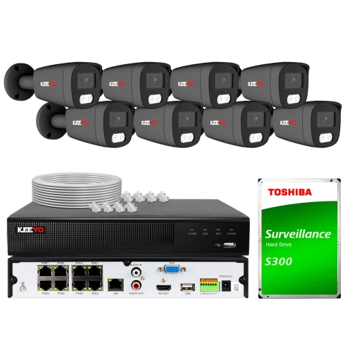 Na zdjęciu znajduje się zestaw do monitoringu, który obejmuje osiem kamer, rejestrator oraz dysk twardy Toshiba S300. W tle widoczne są również kable i akcesoria potrzebne do instalacji systemu.