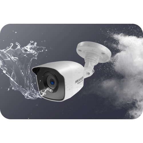 Na zdjęciu znajduje się biała kamera monitoringu z obiektywem skierowanym na wprost, otoczona rozpryskującą się wodą, co sugeruje jej wodoodporność. Kamera jest zamontowana na uchwycie ściennym, a w tle widać efektowne rozmycie przypominające dym lub mgłę.